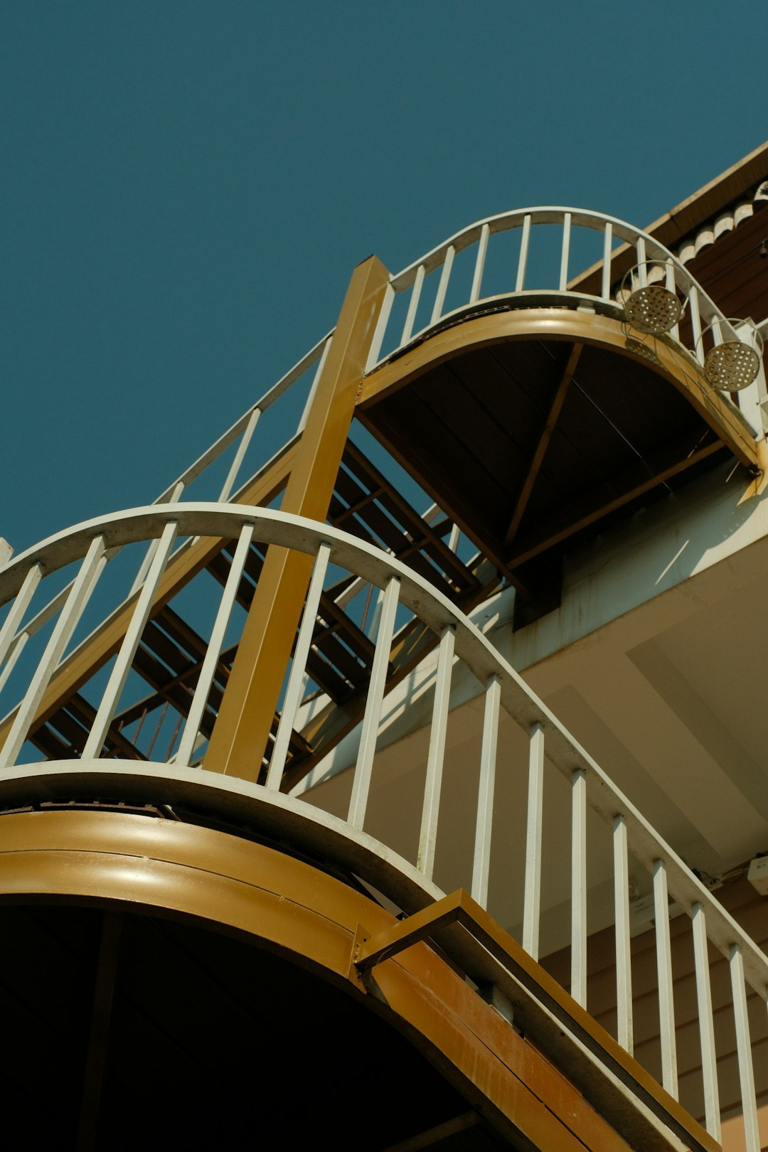 gallery-1 curving-golden-staircase-with-white-railings-against-blue-sky-uci-fioesac